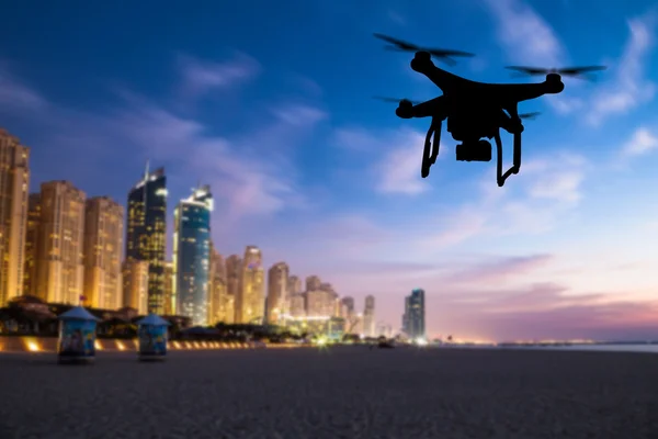 Drone silhouette flying above Dubai city panorama