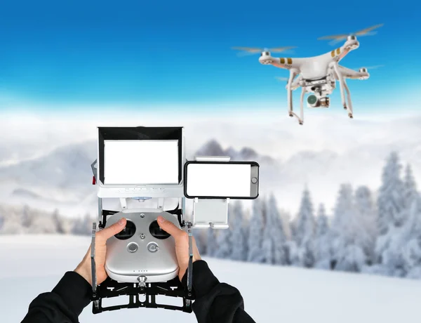 Man hands handling drone in winter landscape