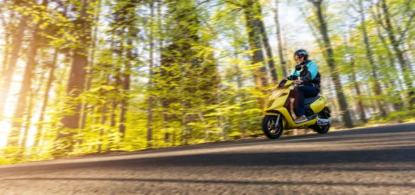 Young man driving scooter, blur motion