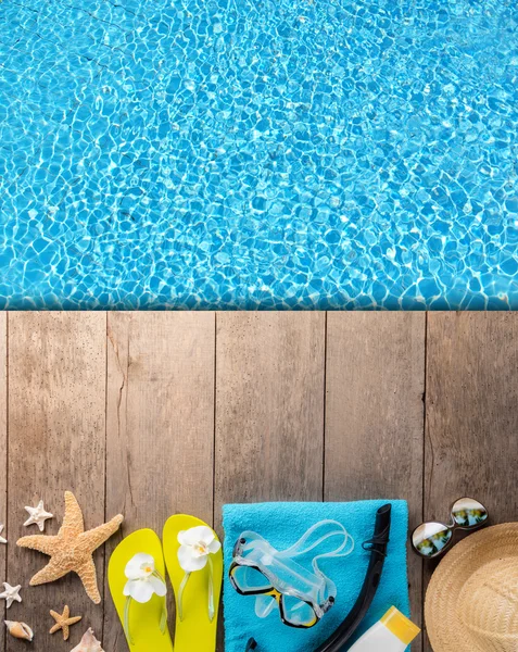 Beach accessories on wooden background with pool