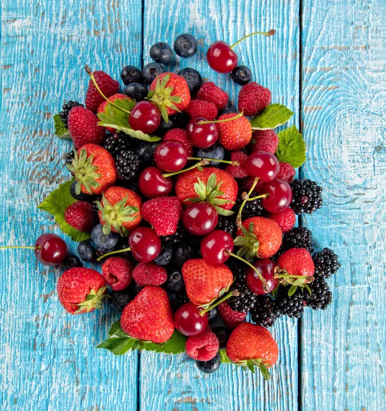 Fresh berry fruit pile placed on old wooden planks