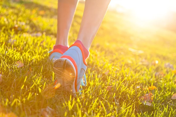 Close up of feet of a runner running in grass
