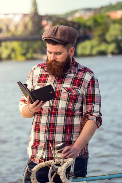 Trendy hipster young man reading digital book