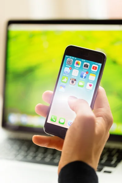 A man hand holding screen Apple app showing on iPhone 6 in office. Apple is the most valuable technology company in the World. PRAGUE, CZECH REPUBLIC - NOVEMBER 17,2015