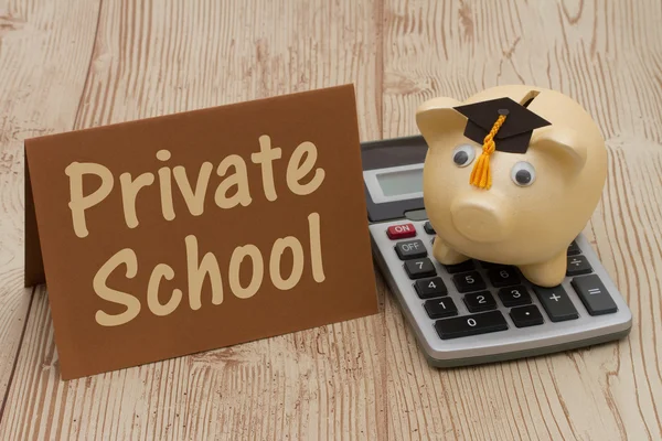 A golden piggy bank with grad cap, card and calculator on wood b