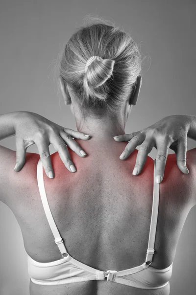 Woman with pain in shoulders. Pain in the human body with red dot