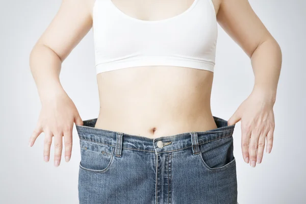 Young woman in jeans of large size, concept of weight loss