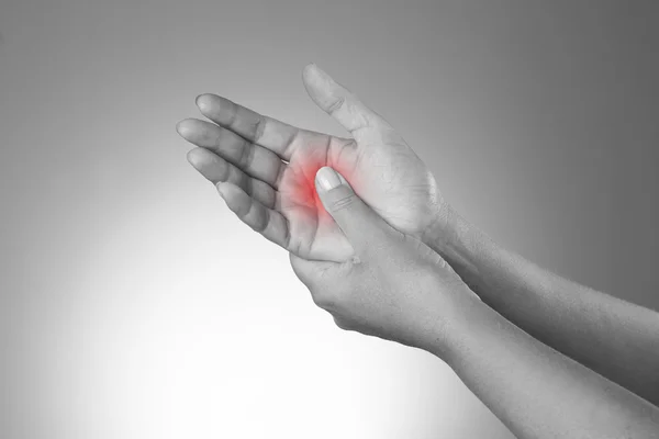 Pain in the joints of the hands. Carpal tunnel syndrome. Pain in the human body on a gray background