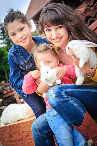 Mother with daughters holding rabbits