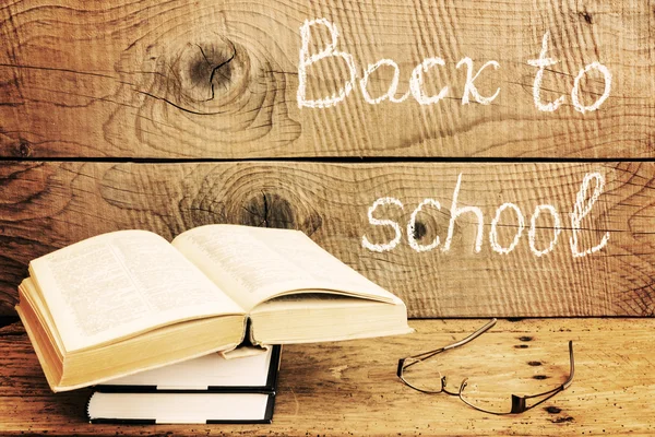 Back to school inscription with books over an rustic table