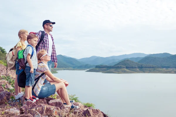 Happy family standing near the lake at the day time.