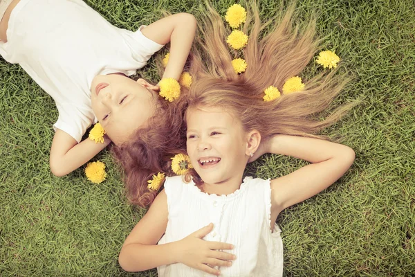 Happy little boy and girl lying on the grass
