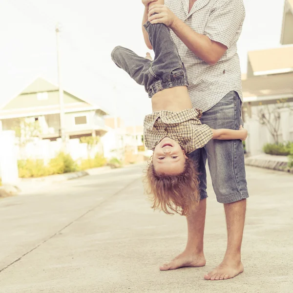 Dad and son playing near a house