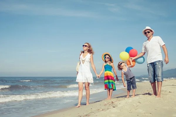 Happy family playing  with balloons on the beach at the day time