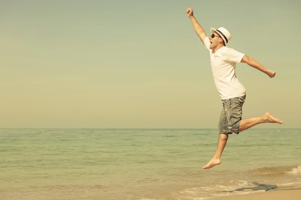 Happy man jumping on the beach