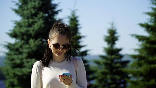 Young woman uses the app on your phone or typing SMS