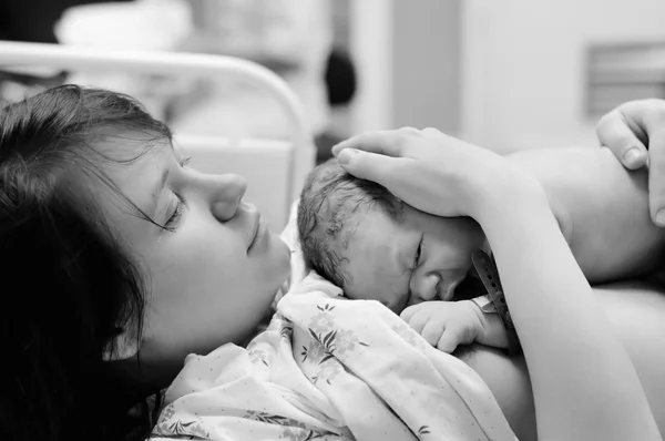 Woman with newborn baby right after delivery