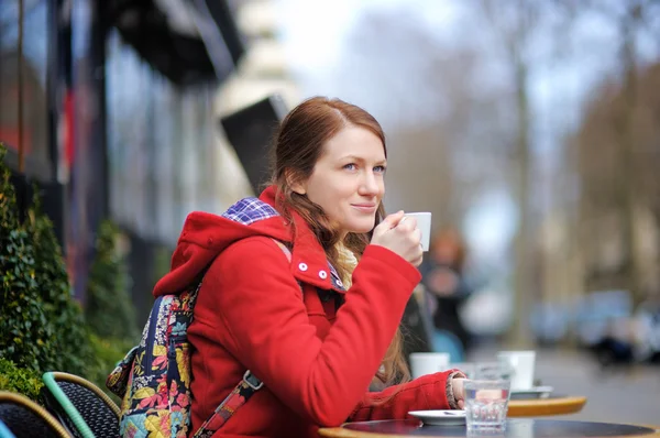 Woman drinking coffee in a street cafe