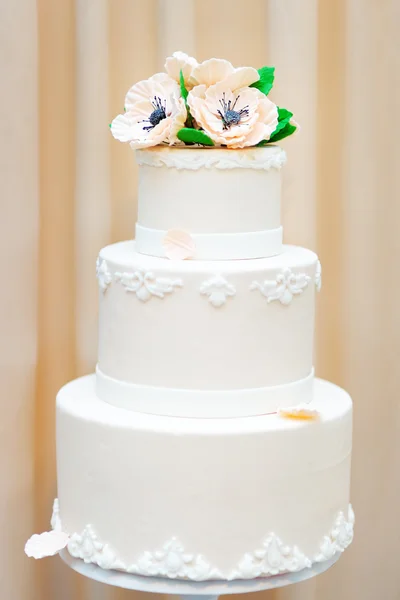 Delicious white wedding or birthday cake decorated with flowers