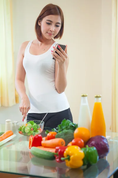 Young woman Following Recipe On mobile phone