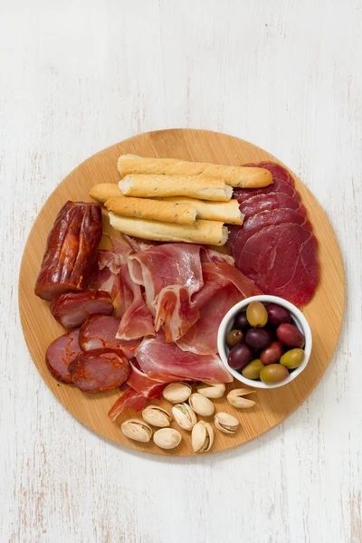 Meat appetizer with olives and nuts on tray