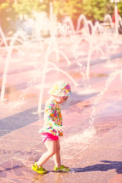 Toddler playing with small fountains