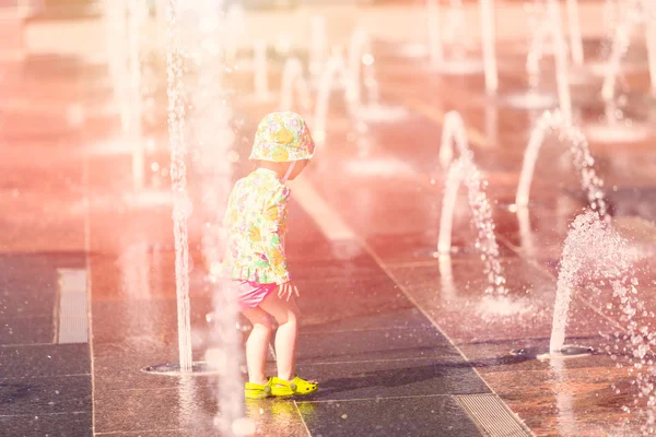 Toddler playing with small fountains