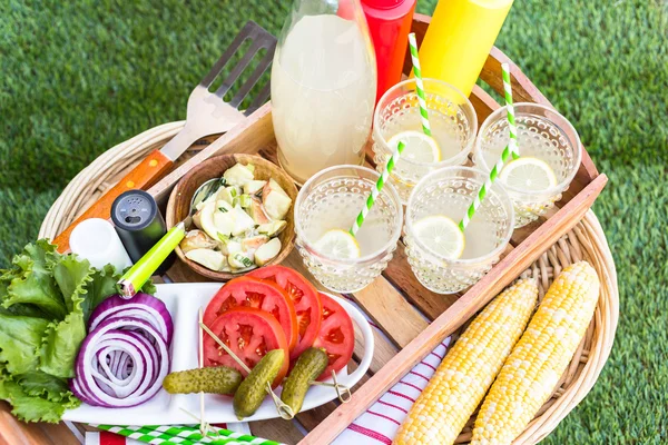 Small summer picnic with lemonade and corn