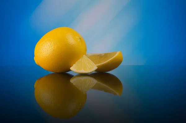 Lemon on a blue abstract background with reflection