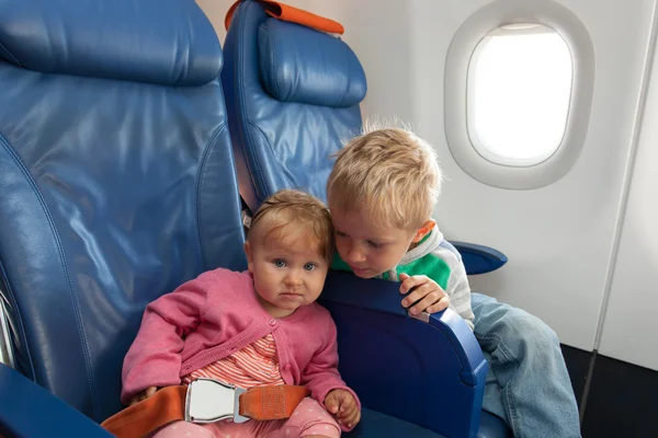 Kids travel by plane - little boy and toddler girl in flight