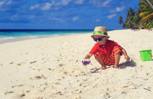 Little boy play with sand on beach