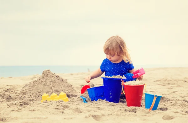 Little girl play with sand on beach