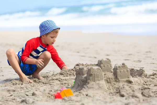 Little boy play with sand on summer beach