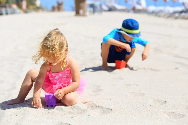 Kids play with sand on summer beach