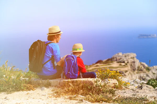 Family travel-father and son hiking in mountains