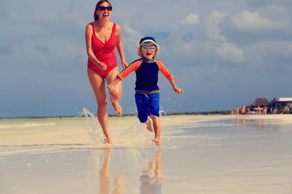 Mother and son running on tropical beach