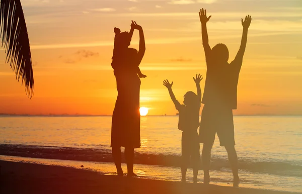 Happy family with two kids having fun at sunset