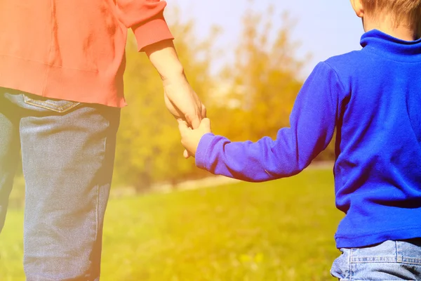 Mother holding hand of her son outdoors