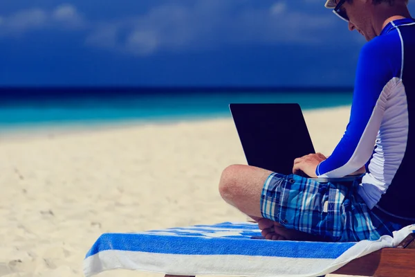 Man with laptop on beach vacation