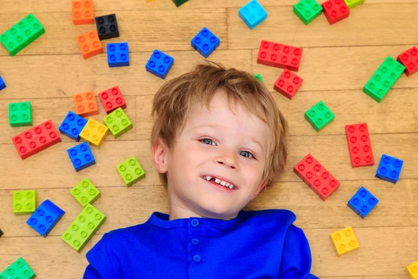 Child playing with colorful plastic blocks indoor