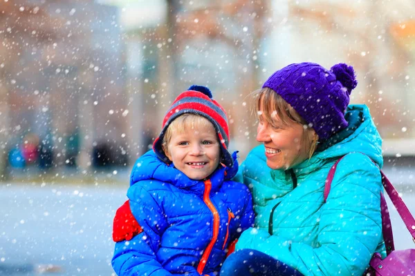 Mother and son enjoy first snow in the city