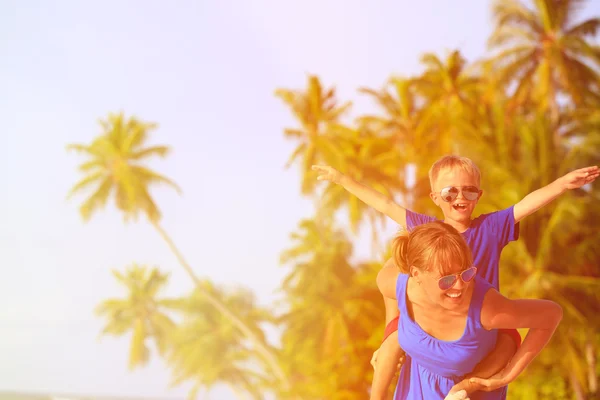 Mother and son flying on the beach