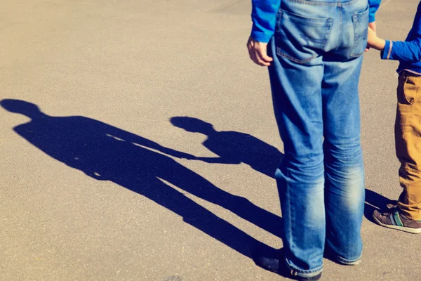 Shadows of father and son holding hands