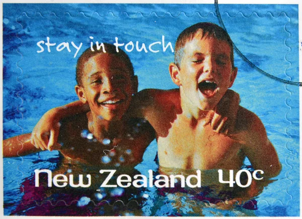 NEW ZEALAND- CIRCA 1998: A stamp printed in New Zealand shows friends at the pool, stay in touch, circa 1998