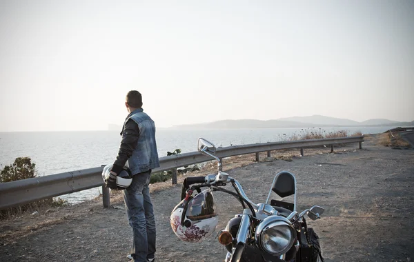 Biker and motorcycle by the sea
