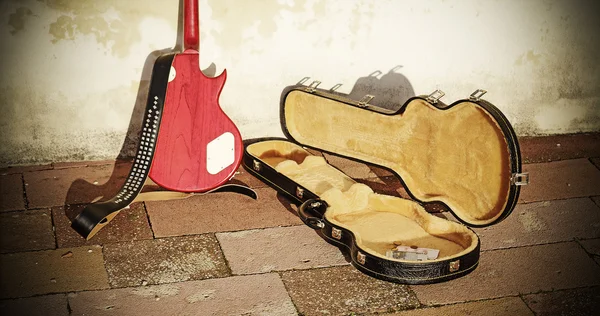Guitar case with coins and bills