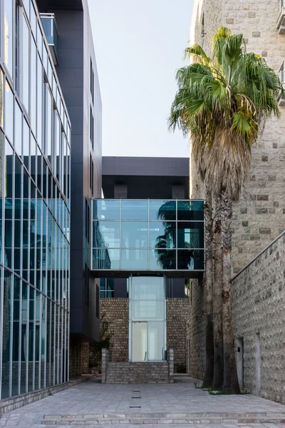 Modern building from glass side by side with ancient building fr