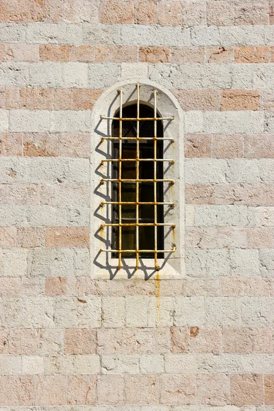Ancient window with cell in the stone wall.