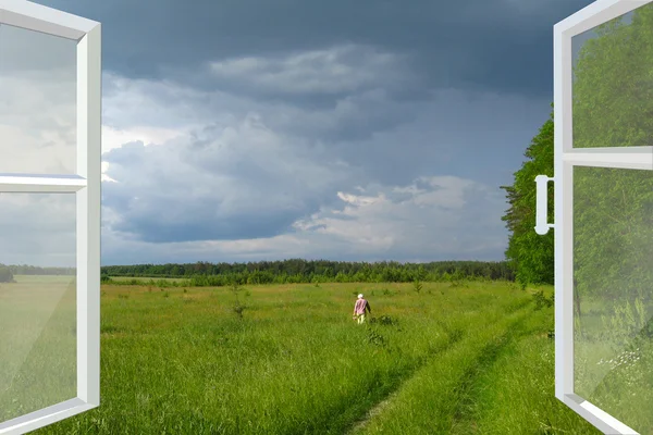 Opened window to summer field before thunder