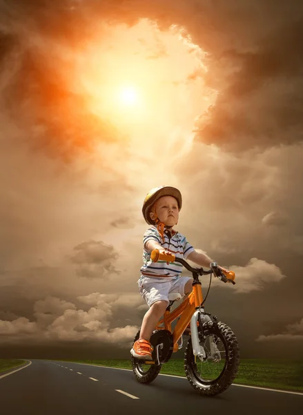 Child on orange bicycle